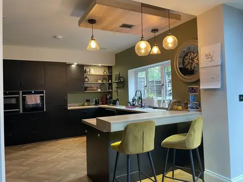 Finished kitchen with three glass pendant lights over a breakfast bar